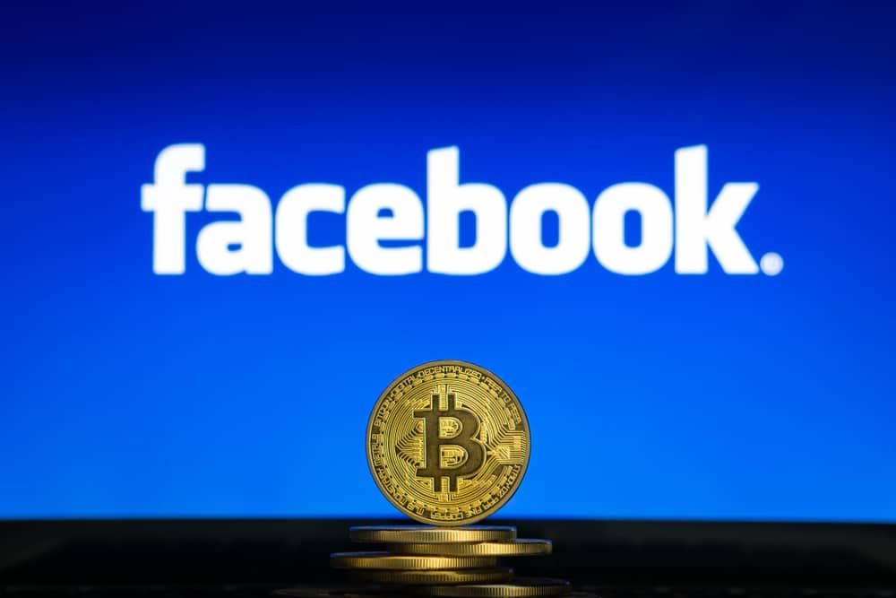 Bitcoin-on-a-stack-of-coins-with-Facebook-logo-on-a-laptop-screen.-Cryptocurrency-and-blockchain-adoption-getting-mainstream.-Slovenia-02-24-2019-Image