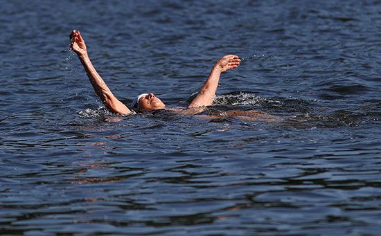 رجل يسبح لمواجهة ارتفاع الحرارة