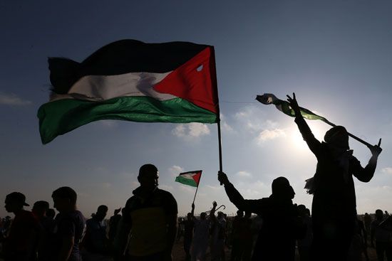المتظاهرين يرفعون الاعلام الفلسطينية