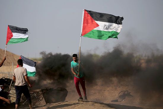 شاب فلسطينى يرفع علم فلسطين