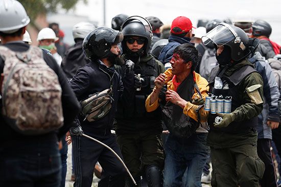 أفراد من قوات الأمن يعتقلون رجلاً مصاباً أثناء الاشتباكات بين مؤيدي إيفو موراليس وأنصار المعارضة في لاباز