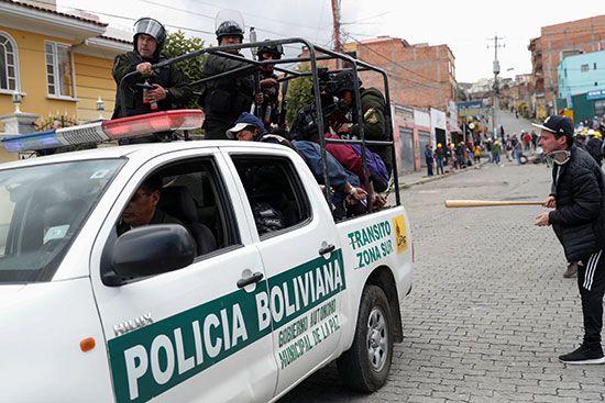 ضباط الشرطة يحملون متظاهرين احتُجزوا خلال اشتباكات بين أنصار الرئيس البوليفي إيفو موراليس وأنصار المعارضة في لاباز
