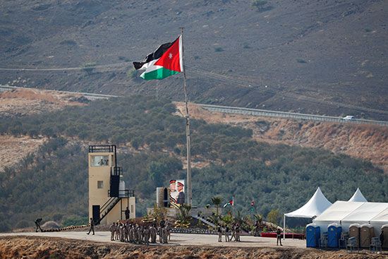 جنود أردنيون يتجمعون بالقرب من العلم الوطني الأردني  في منطقة باقورة