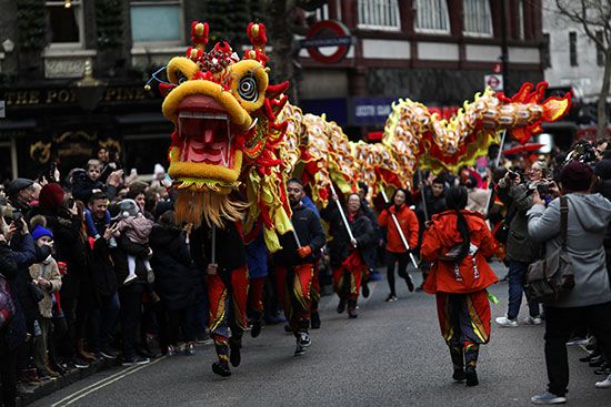 ينقل المؤدون تنينًا صينيًا خلال عرض السنة القمرية الصينية الجديدة وسط لندن