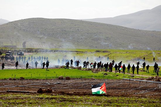متظاهرون فلسطينيون يفرون من الغاز المسيل للدموع