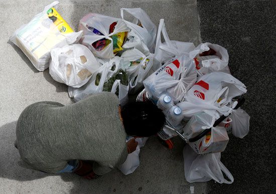 امرأة تحزم شرائها من مواد البقالة أثناء تخزينها للمواد الغذائية
