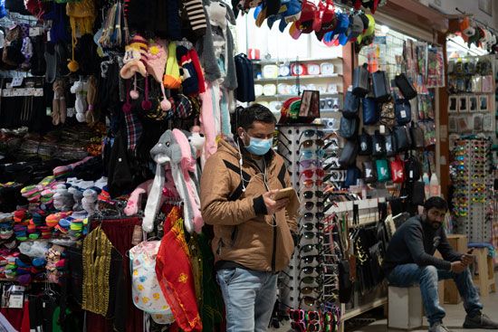 شخص يقف داخل السوق يرتدى الكمامة شخص يقف داخل السوق يرتدى الكمامة