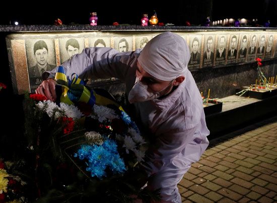 رجل يضع ورود على النصب التذكارى لضحايا تشرنوبل