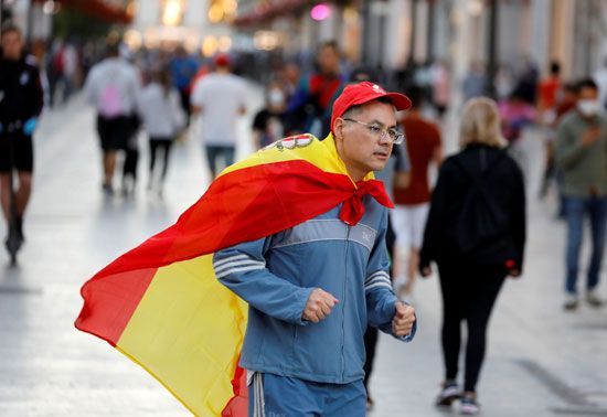 متظاهر يرفع علم اسبانيا
