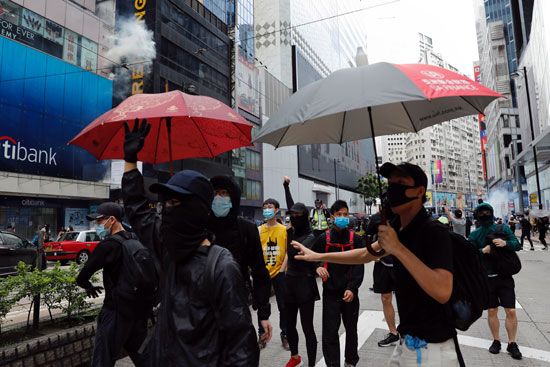 المتظاهرون بشوارع هونج كونج يرتدون الأقنعة
