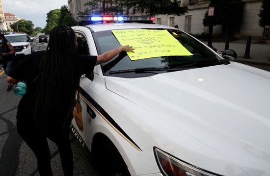 المحتجون يضعون لافتات على سيارات الشرطة