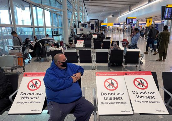 أحد المسافرين يجلس بمبنى مطار هيثرو