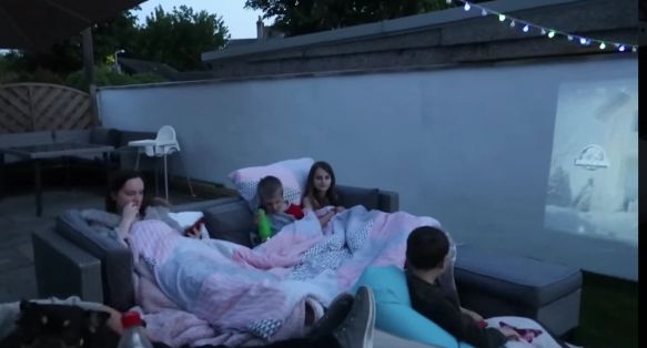 الاطفال يجلسون فى حديقة المنزل لمشاهدة السينما