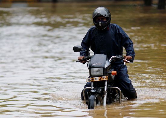 السباحة بالدراجة البخارية كأحد أهم وسائل التنقل فى الهند بسبب الأمطار