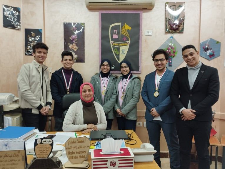 التفاف الطلاب الفائزين فى مسابقة معرض مصر للعلوم  بجوار مديرة المدرسة