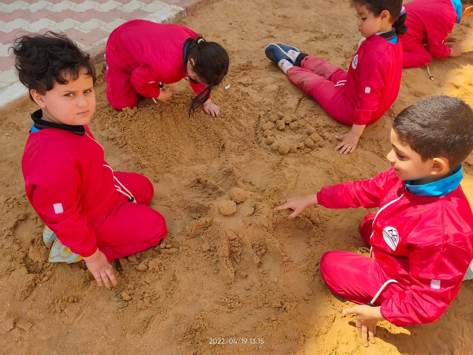 الاطفال يرسمون في الرمال