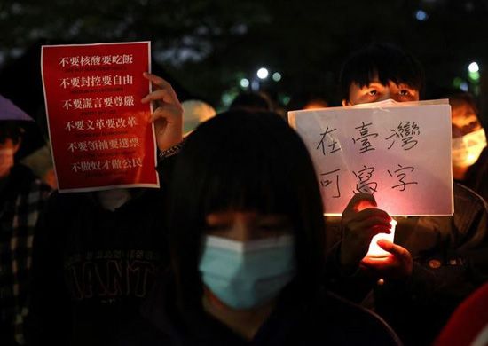 الناس يحملون الشموع واللافتات لدعم الاحتجاجات في الصين في جامعة تايوان الوطنية